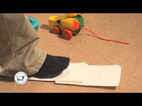 Foot stepping on paper towels to blot a spill on carpet.